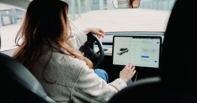 woman in white sweater driving car